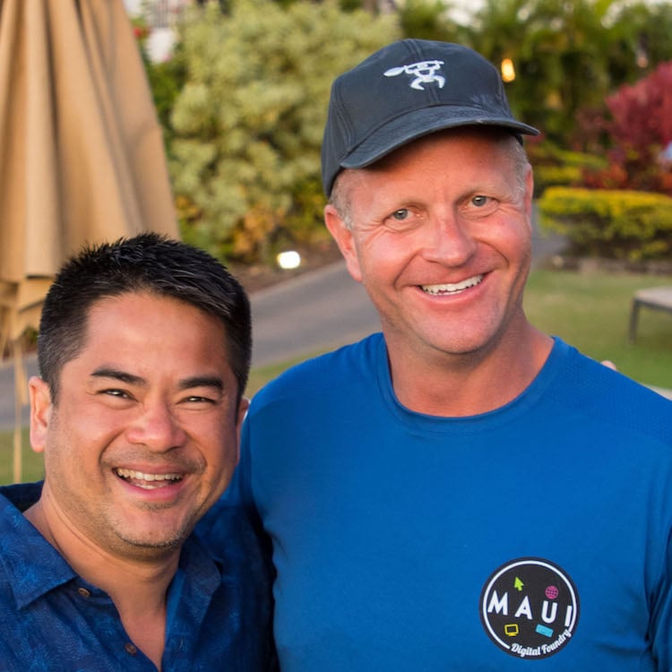Two smiling team members, one in a baseball hat and Maui t-shirt.
