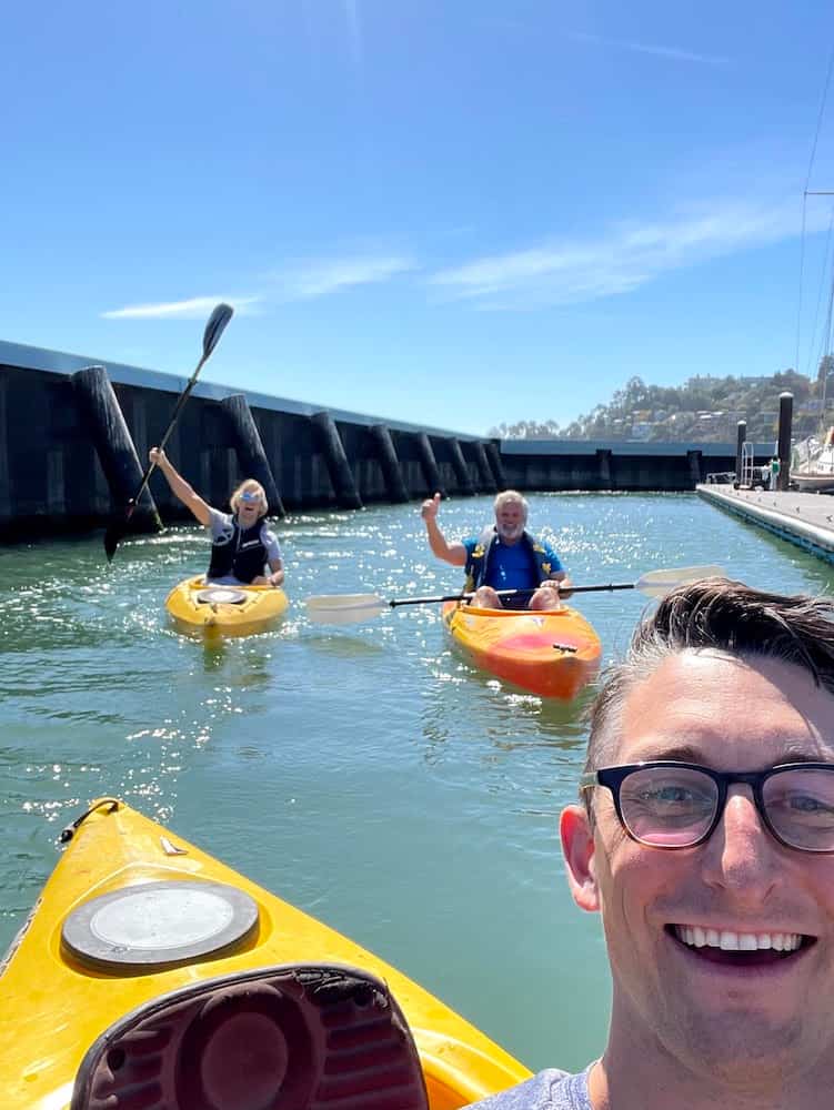 Selfie on a kayak with two kayaks in the background.