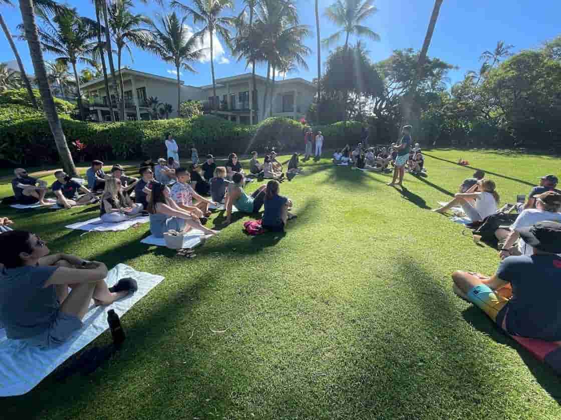 Outdoor meeting under palm trees.