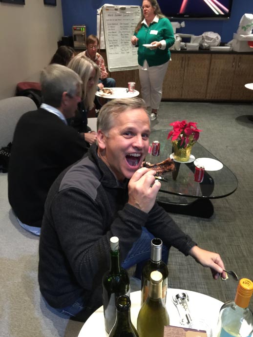Smiling Digital Foundry team member taking a large bite of BBQ ribs.