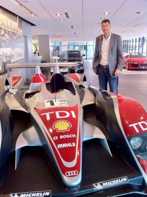 Admiring a Formula 1 race car sponsored by a client.