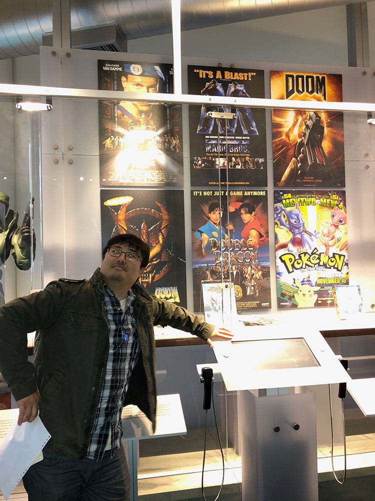 Digital Foundry team member leaning against a game screen in a video arcade.