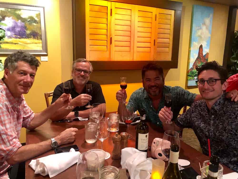 Group of four toasting with wine at dinner.