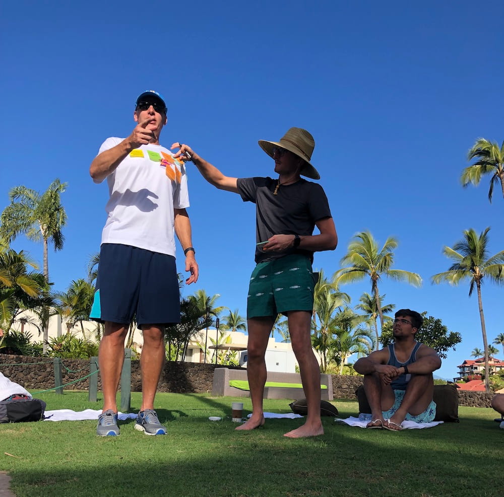 Putting sticky notes on the t-shirt of a colleague at an outdoor meeting.