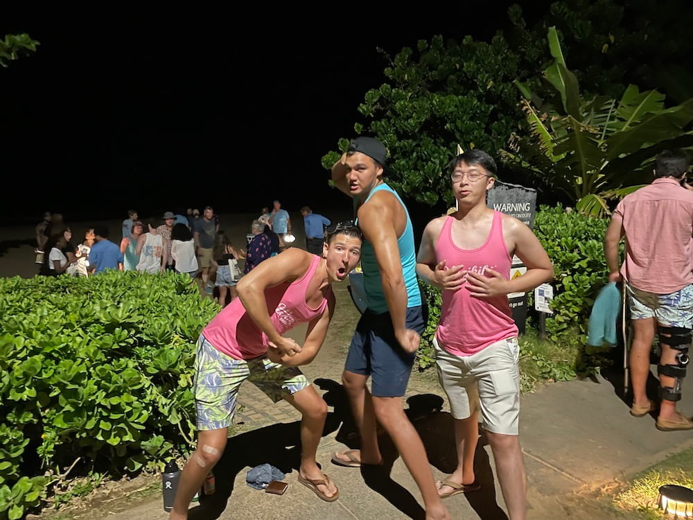 Three men in tank tops in humorous muscle-man poses.
