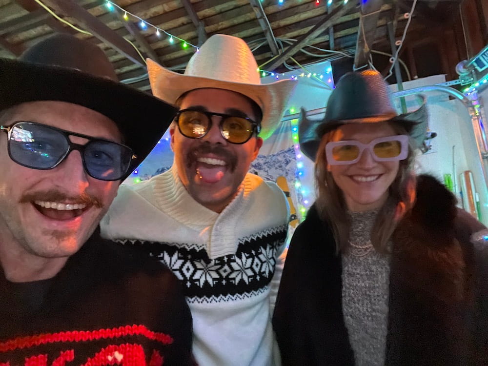 Three people wearing cowboy hats and large sunglasses.
