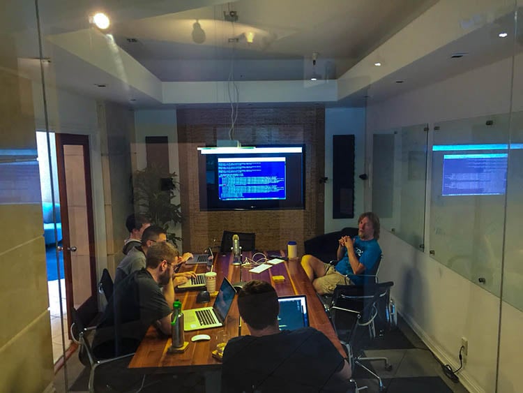 Several Digital Foundry software engineers working on laptops around a conference table.