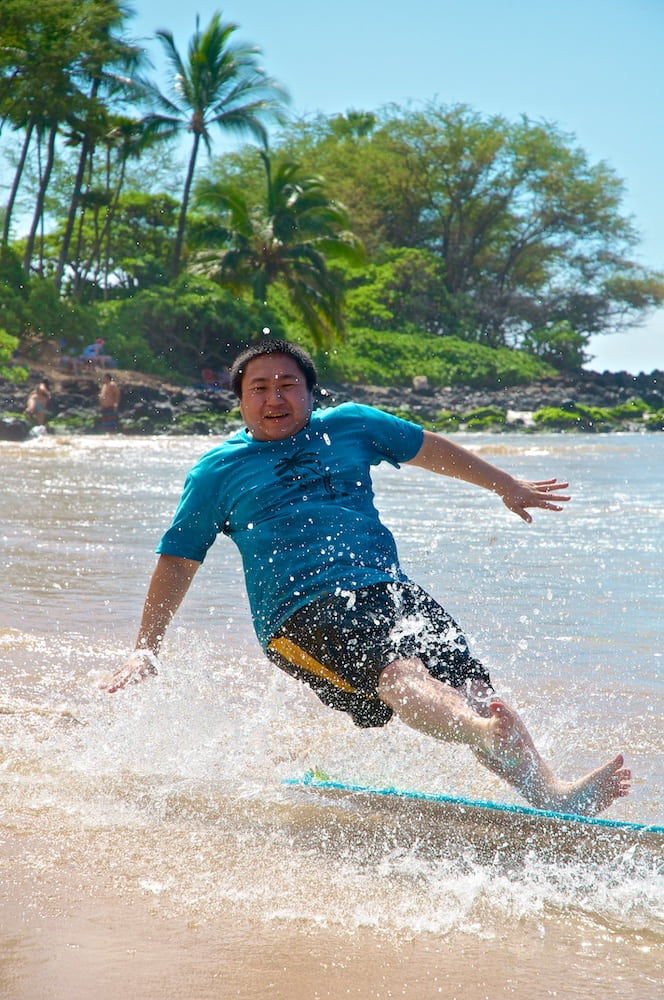Action shot of falling off a skimboard at the beach.