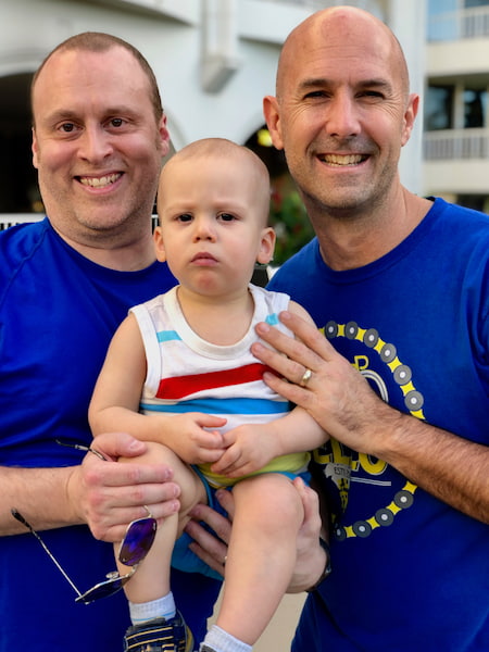 Team members holding a frowning baby.